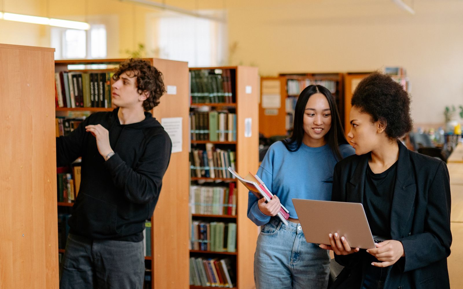 Étudiants consultant des ouvrages et des documents dans une bibliothèque universitaire